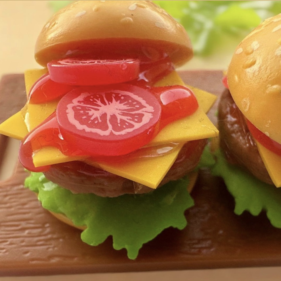 a close up picture of a burger with lettuce cheese and tomato